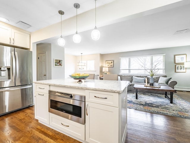 kitchen featuring light stone counters, open floor plan, white cabinets, stainless steel refrigerator with ice dispenser, and dark wood-style flooring