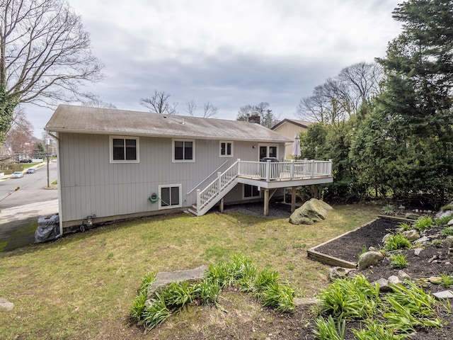back of property with a wooden deck, a yard, and stairs