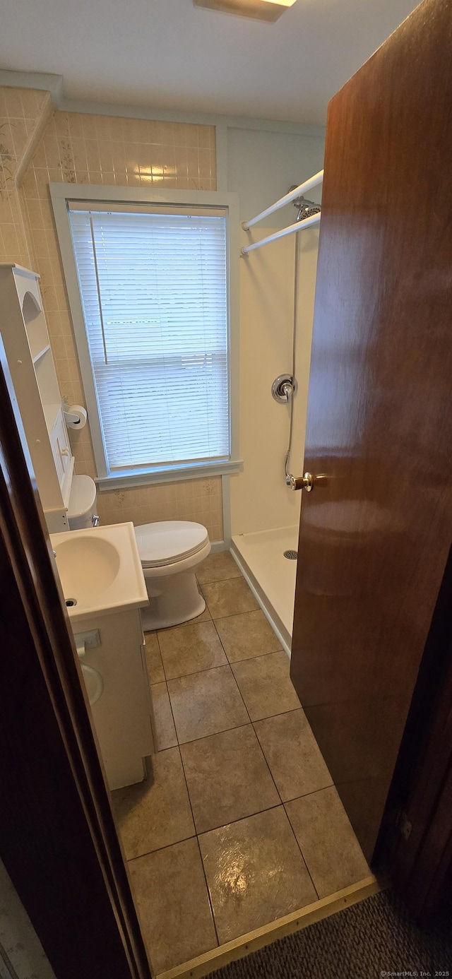 bathroom featuring a shower stall, toilet, tile patterned flooring, and vanity