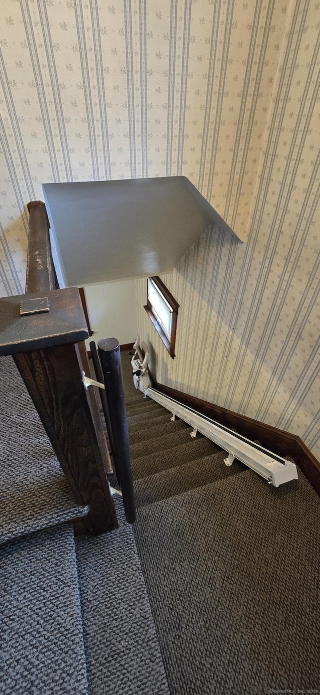 staircase with baseboards, carpet floors, and wallpapered walls
