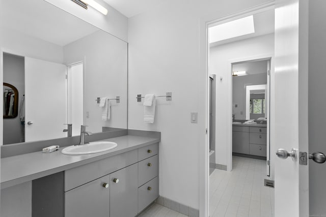 full bath with visible vents, walk in shower, baseboards, vanity, and tile patterned flooring