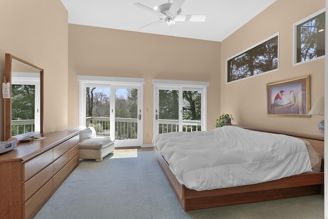 carpeted bedroom with ceiling fan, a towering ceiling, and access to exterior