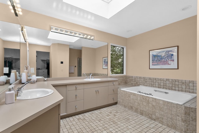 full bathroom featuring a skylight, a garden tub, and vanity