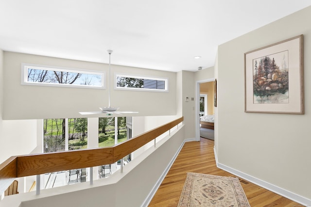 corridor with light wood-style floors and baseboards