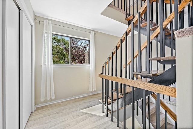 stairs with wood finished floors and baseboards