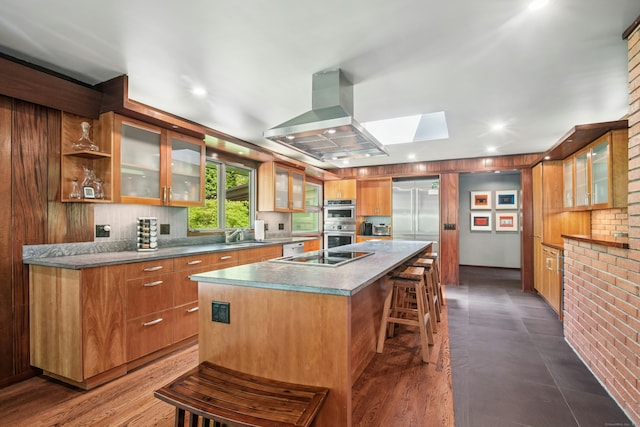 71 Boulderol Rd, Stamford, CT 06903 - kitchen with island range hood, a skylight, double oven, a center island with sink, and a breakfast bar area