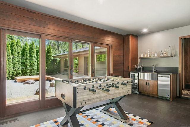 71 Boulderol Rd, Stamford, CT 06903 - rec room featuring beverage cooler, bar with sink, dark tile patterned floors, recessed lighting, and wood walls