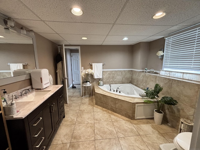 full bathroom featuring tile patterned floors, a bath, a drop ceiling, and vanity
