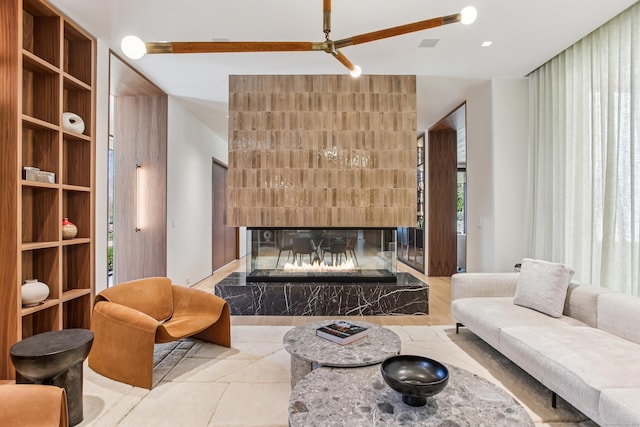 tiled living room featuring a multi sided fireplace