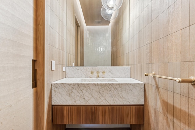 bathroom with vanity and tile walls