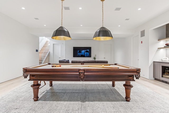 recreation room featuring light wood finished floors, a glass covered fireplace, billiards, and recessed lighting