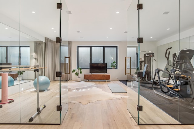workout room with wood finished floors, plenty of natural light, and recessed lighting