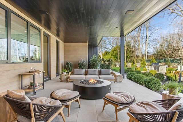view of patio / terrace with an outdoor living space with a fire pit and an outdoor kitchen