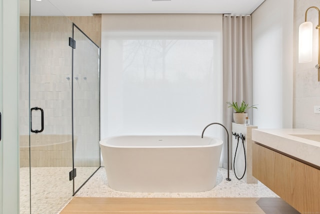 bathroom featuring a soaking tub, a stall shower, and vanity