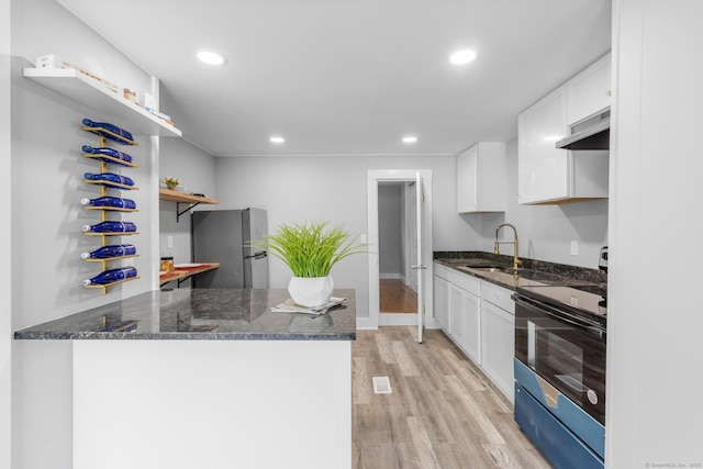 kitchen with open shelves, freestanding refrigerator, electric stove, under cabinet range hood, and a sink