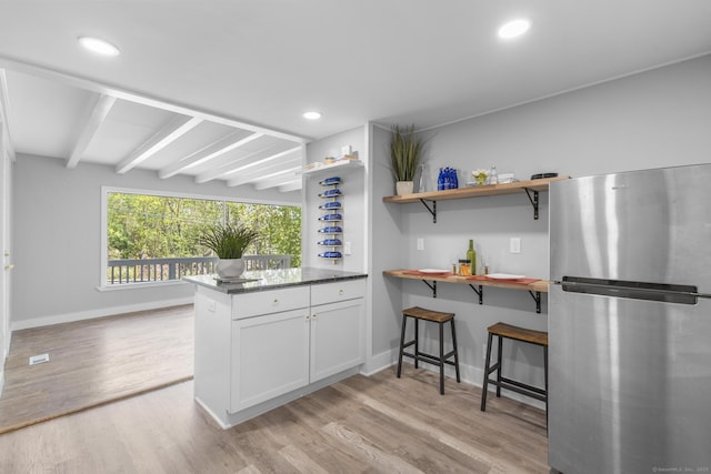 kitchen with white cabinets, open shelves, light wood-style flooring, freestanding refrigerator, and baseboards
