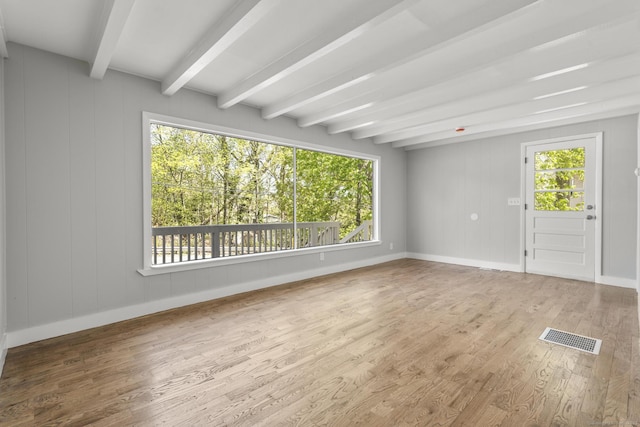 interior space featuring visible vents, wood finished floors, a wealth of natural light, and beamed ceiling