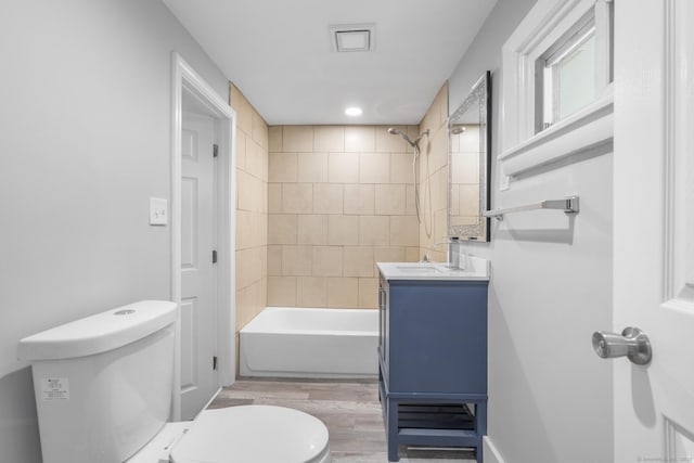 full bath with vanity, shower / bathtub combination, wood finished floors, and toilet