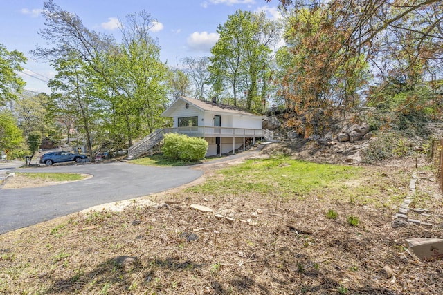 view of side of home with stairs and driveway