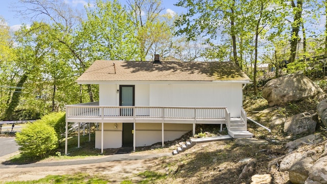 rear view of house with a chimney and a deck