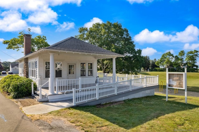 37 Woodland Dr, Old Saybrook, CT 06475 - view of front of home with a chimney, a front lawn, roof with shingles, and covered porch