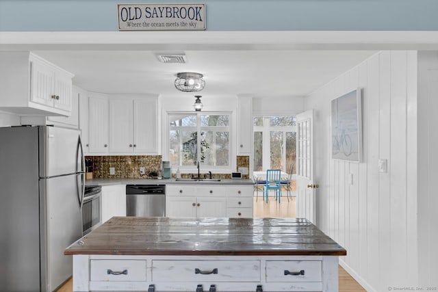 37 Woodland Dr, Old Saybrook, CT 06475 - kitchen with stainless steel appliances, dark countertops, a sink, and white cabinetry