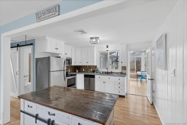 37 Woodland Dr, Old Saybrook, CT 06475 - kitchen with appliances with stainless steel finishes, a sink, dark countertops, and light wood-style floors