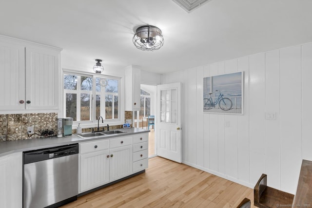 37 Woodland Dr, Old Saybrook, CT 06475 - kitchen with stainless steel dishwasher, a sink, light wood-style floors, and white cabinets