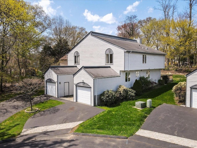 view of front of property with a chimney, driveway, and a front lawn