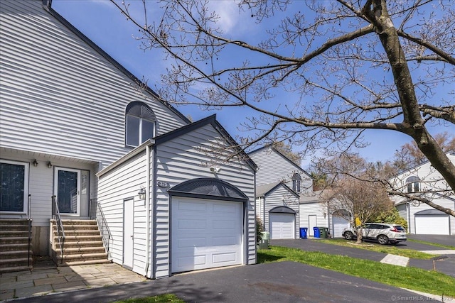 view of property exterior with entry steps and a garage