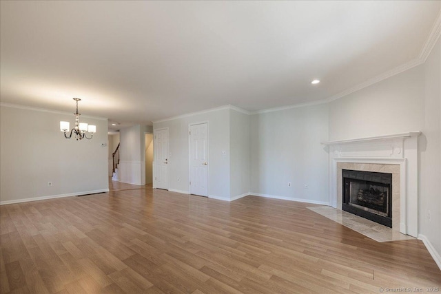 unfurnished living room with light wood-style floors, a chandelier, and a tile fireplace