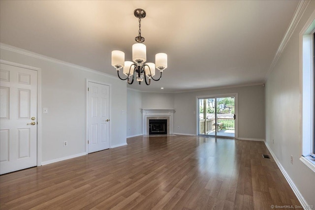 unfurnished living room with wood finished floors, baseboards, ornamental molding, and a notable chandelier