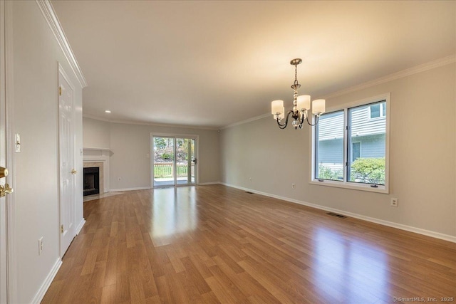 unfurnished living room with a chandelier, crown molding, baseboards, and light wood-type flooring