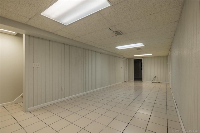 empty room with light tile patterned flooring and a drop ceiling