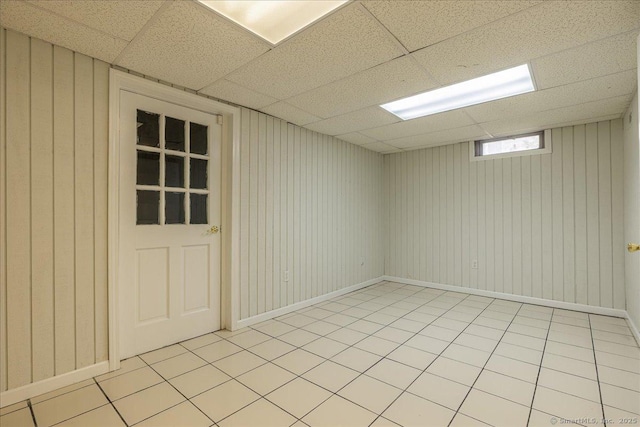 empty room featuring a paneled ceiling and light tile patterned floors