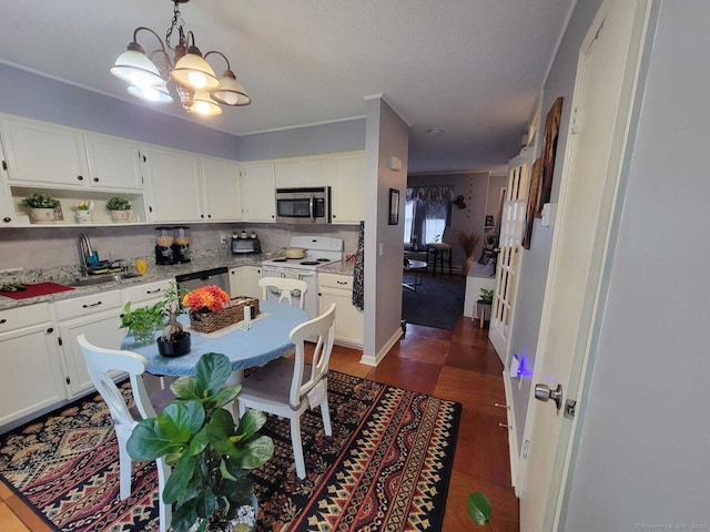 24 Deerwood Ln Unit 3, Waterbury, CT 06704 - kitchen featuring open shelves, a chandelier, white cabinetry, hanging light fixtures, and stainless steel appliances