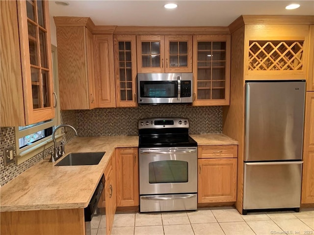 kitchen featuring tasteful backsplash, light countertops, a sink, and appliances with stainless steel finishes