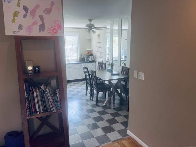 dining area with dark floors, baseboards, and a ceiling fan