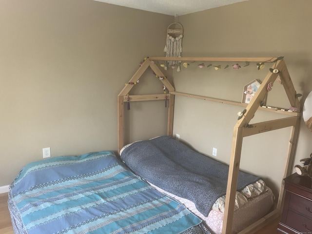 bedroom featuring baseboards and wood finished floors