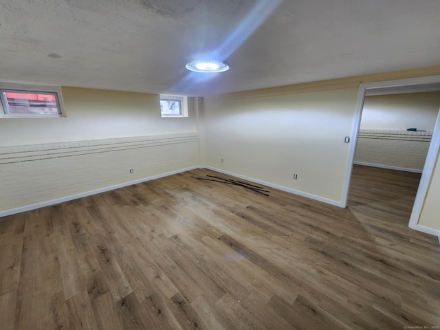 below grade area featuring baseboards and wood finished floors