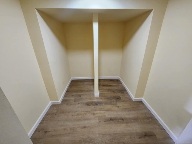 basement featuring baseboards and wood finished floors