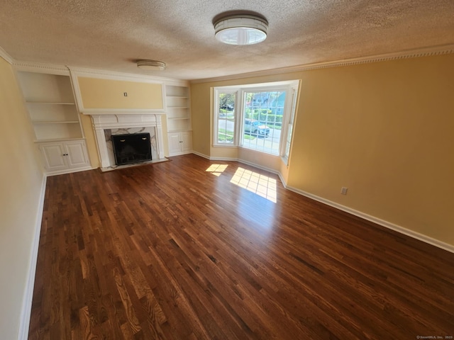 20 Rosina Rd, Hamden, CT 06514 - unfurnished living room with a textured ceiling, dark wood-style flooring, a fireplace, built in shelves, and crown molding