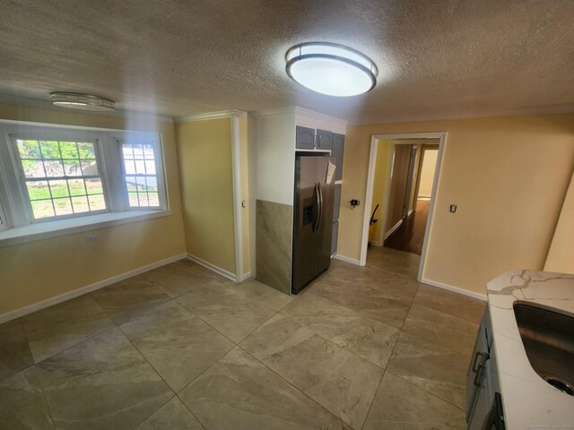 interior space with a sink, baseboards, and a textured ceiling