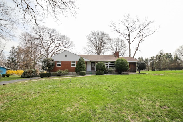 ranch-style home featuring a front yard and a chimney