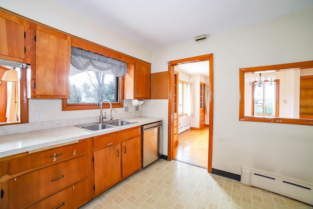 kitchen with a sink, light countertops, dishwasher, and baseboard heating