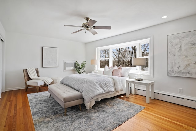 bedroom with light wood-type flooring, a wall mounted AC, a ceiling fan, and recessed lighting