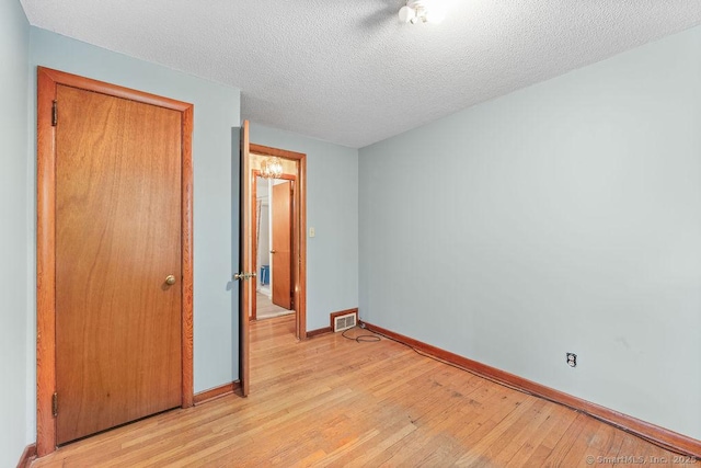 287 Prospect St, Wethersfield, CT 06109 - unfurnished bedroom with light wood-type flooring, baseboards, and a textured ceiling