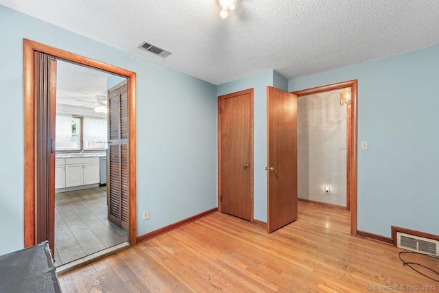 287 Prospect St, Wethersfield, CT 06109 - unfurnished bedroom featuring light wood-type flooring, baseboards, a closet, a textured ceiling, and ensuite bathroom