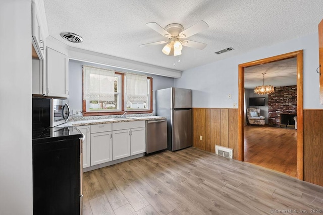 287 Prospect St, Wethersfield, CT 06109 - kitchen featuring stainless steel appliances, a wainscoted wall, a textured ceiling, a sink, and ceiling fan
