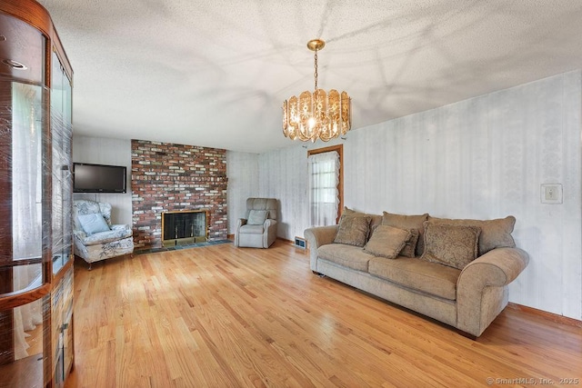 287 Prospect St, Wethersfield, CT 06109 - living room featuring wood finished floors, a chandelier, a fireplace, and a textured ceiling